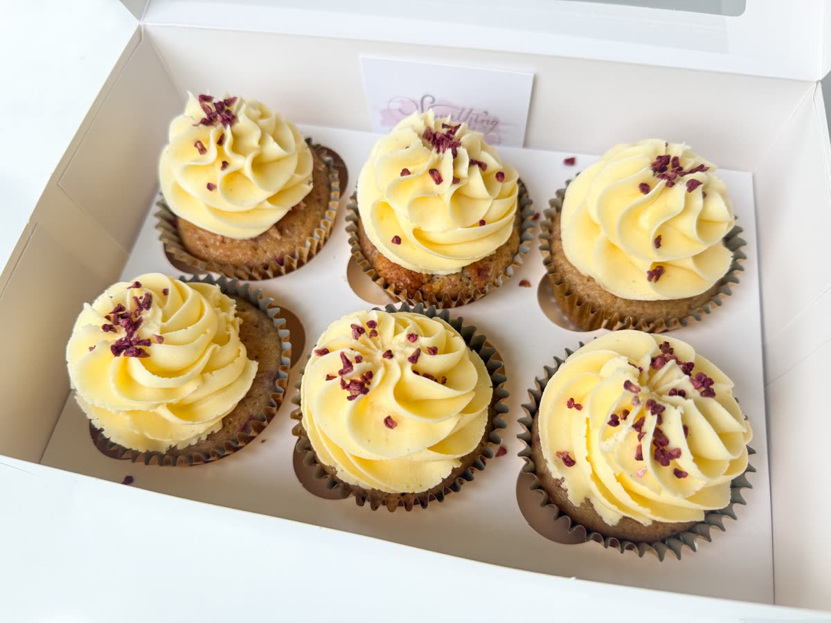 Box of six vanilla cupcakes topped with buttercream swirls and sprinkles